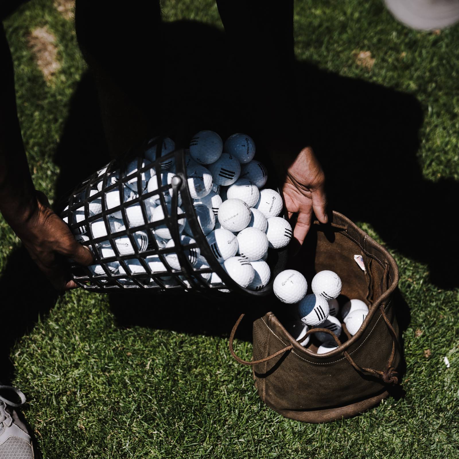 Person Pouring Golf Balls In Brown Leather Bag 1325733